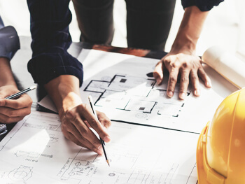 Aerial view of several engineers reviewing blue prints