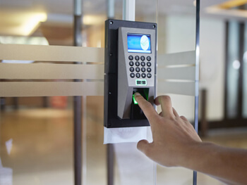 Hand pushing buttons on a security system panel